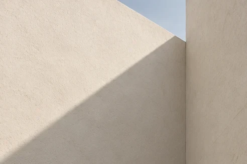 Light and shadow across pale concrete walls